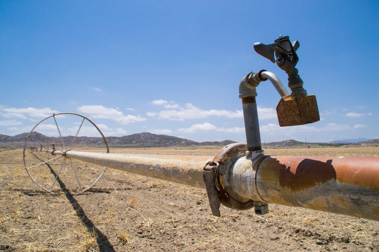 Una tubería de agua a través de tierras de cultivo secas.