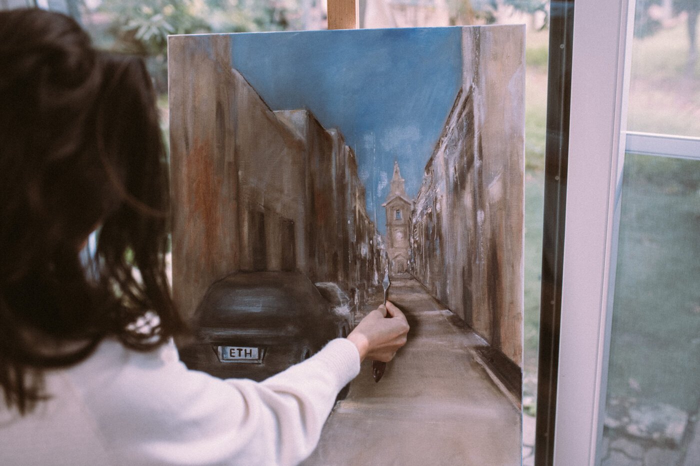 Escena callejera de mujer pintando en el estudio del artista.