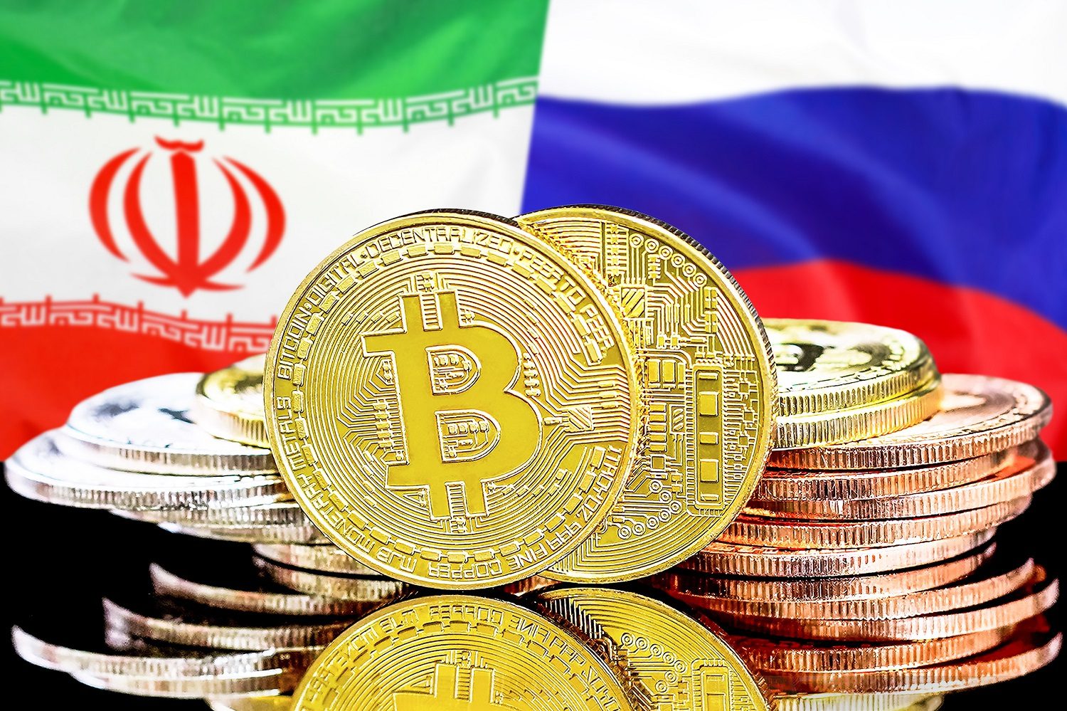 Una pila de monedas destinadas a representar tokens de Bitcoin en el contexto de las banderas de Irán y Rusia.