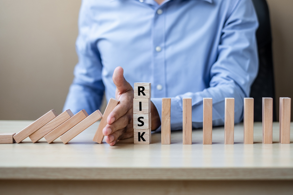 A businessman holding a wooden block with the word risk on it.