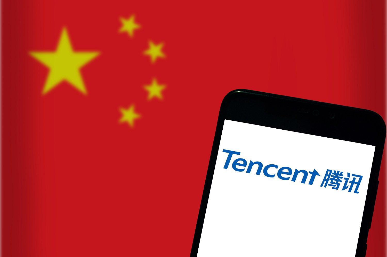 El logotipo de Tencent en la pantalla de un teléfono móvil con el telón de fondo de una bandera china.