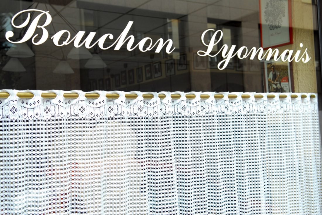El exterior de un restaurante con Bouchon Lyonnais escrito en la ventana.