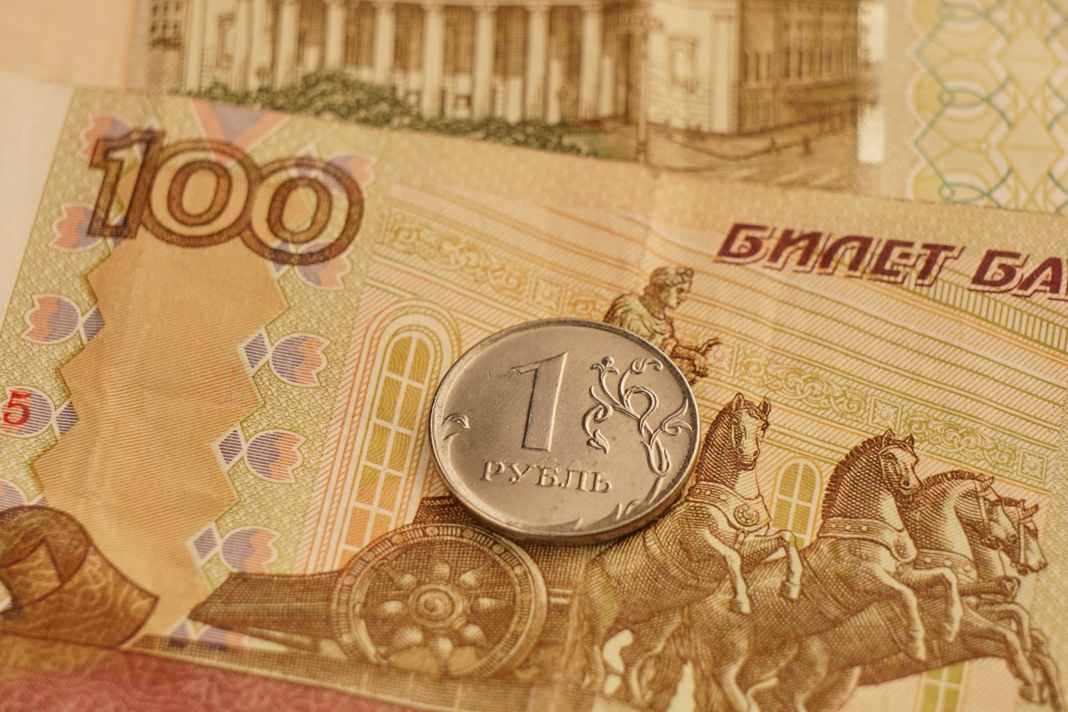 Una moneda de un rublo descansa sobre billetes de papel rusos.